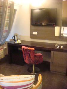 巴黎巴黎蒙马特智选假日酒店的客房设有书桌、电视和椅子