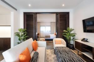 阿布扎比阿联酋公园度假酒店的客厅配有白色沙发和橙色枕头。