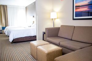 海沃德Holiday Inn Express & Suites Hayward, an IHG Hotel的酒店客房设有一张沙发和一张床