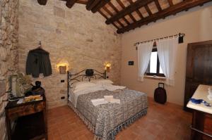 AbbateggioAgriturismo Borgo San Martino的一间卧室设有一张床和石墙