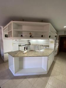 皮拉尔RondPoint Pilar的厨房配有白色橱柜和台面