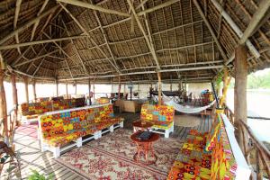 乌罗阿Zanzibar Bay Resort & Spa的度假村内带椅子和吊床的房间