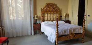 瓦雷泽卡格罗纳别墅酒店的一间卧室配有一张木架大床