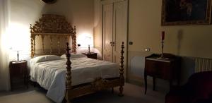 瓦雷泽卡格罗纳别墅酒店的一间卧室配有一张天蓬床和梳妆台