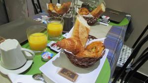 巴黎Hôtel de Choisy的一张桌子,上面放着两篮糕点和两杯橙汁