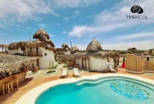 维加伊托Maracol Bungalows Vichayito的一个带游泳池和茅草遮阳伞的度假村