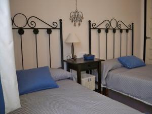 内尔哈卡波斯特拉诺苏尔酒店的一间卧室配有两张床和一张带台灯的桌子