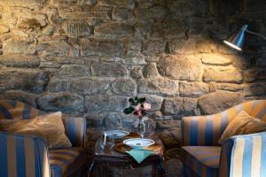 拉达-因基安蒂沃尔帕伊亚卡斯特洛乡村民宿的一张桌子,房间内设有两把椅子和石墙