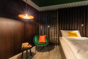 Macardo Premium B&B的一间卧室配有一张床和一把绿色椅子