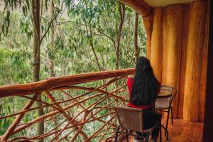 圣特雷莎盖丘亚生态山林小屋的坐在门廊椅子上的女人