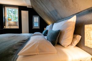 布劳恩拉格country-suites by verdino LIVING - Apartments & Suites的卧室配有带白色枕头的大床
