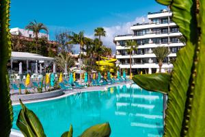 美洲海滩比塔科拉斯普林酒店的一个带椅子的游泳池和一个位于酒店后面的酒店