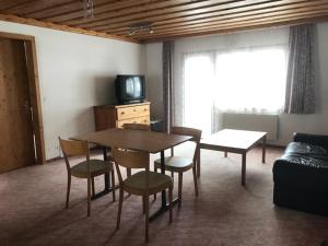 安特瓦塞尔阿尔宾纳酒店的客厅配有桌椅和电视。