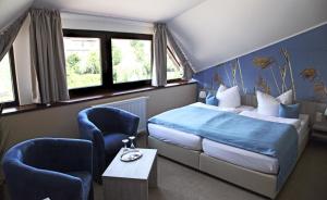 拉特诺Zum Alten Hafen的一间卧室配有一张床、两把椅子和一张桌子