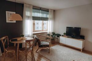 巴尔维Teatra street apartment的客厅配有桌子和电视