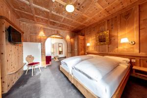 施库尔菲力酒店的一间带一张大床的卧室,位于带木墙的房间