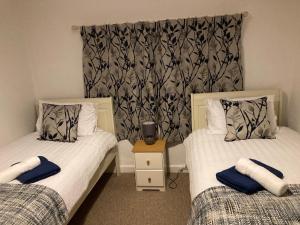 Holcot Cottage的一间卧室配有两张带毛巾的床