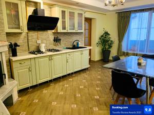 莫申Зелений Дім - ViriDi House的厨房铺有木地板,配有白色橱柜。