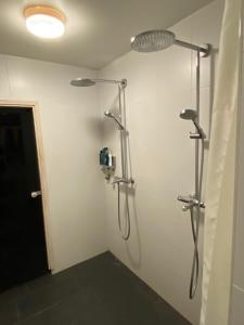 凯尔赛迈基Guesthouse Kärsämäki的墙上带两个淋浴系统的浴室