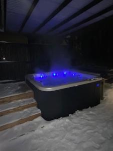 凯尔赛迈基Guesthouse Kärsämäki的雪中带蓝色灯光的浴缸