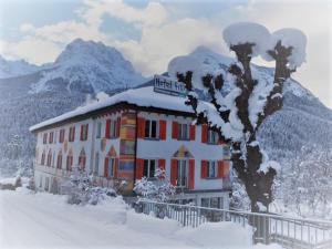 施库尔菲力酒店的一座被雪覆盖的建筑,背景是群山