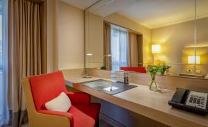 圣保罗InterContinental São Paulo, an IHG Hotel的酒店客房配有书桌和红色椅子