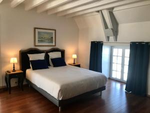 圣马洛圣马洛1685庄园酒店的一间卧室配有一张带蓝色窗帘的大床
