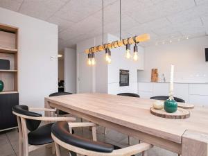 布拉万德8 person holiday home in Bl vand的厨房以及带木桌和椅子的用餐室。