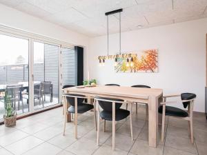 布拉万德8 person holiday home in Bl vand的一间带木桌和椅子的用餐室