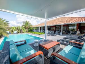 简蒂埃尔Luxurious Villa in Jan Thiel with Pool的一个带躺椅和遮阳伞的游泳池