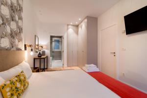 圣塞瓦斯蒂安Liberty Suites by Santiago with AC的卧室配有一张白色大床和电视。