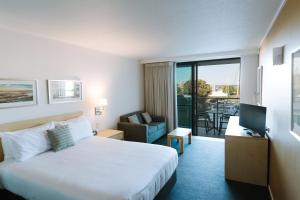 巴利纳Ramada Hotel & Suites by Wyndham Ballina Byron的酒店客房,配有床和电视