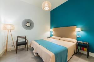 马拉加Debambú Larios的一间卧室设有一张床和蓝色的墙壁