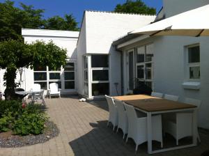 斯文堡Kathrines Bed & Breakfast的庭院配有木桌和白色椅子
