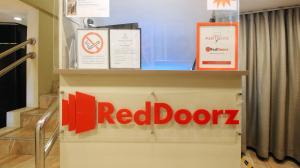 马尼拉RedDoorz at Hotel Rosemarie的大楼一侧的红色门标