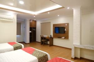 丹戎潘丹Joyful Hotel的酒店客房配有两张床和一张书桌