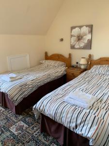 大雅茅斯Kings Lodge Hotel的一间卧室配有两张床和一张带台灯的桌子