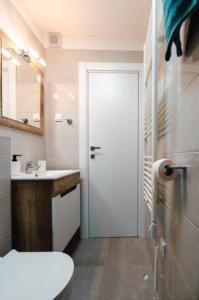 扎达尔Kailani Luxury Central 3 Bedroom, 3 Bathroom Apartment With a Sunny Balcony的一间带卫生间、水槽和门的浴室
