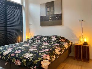 格罗宁根Het Hoekje - 2 bedroom family friendly city home的一间卧室配有一张带花卉棉被的床