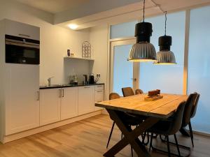 格罗宁根Het Hoekje - 2 bedroom family friendly city home的厨房以及带木桌的用餐室。