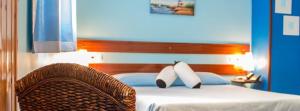 里瓦德奥Hotel A. G. Porcillan的卧室内的一张带两个枕头和椅子的床