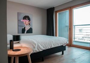 布鲁塞尔Smartflats Design - L42的一间卧室配有一张床、一张桌子和一幅画