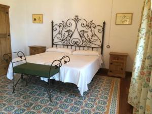 贝纳卢普-卡萨斯维耶哈斯洛斯蒙特洛斯农庄酒店的卧室配有白色的床和绿色椅子