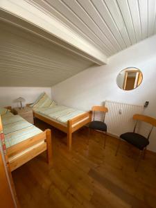 WimbachFerienhaus Jüngling的一间设有两张床和两把椅子的房间