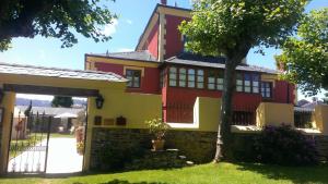 巴雷罗斯卡萨梅洛乡村民宿 的院子里有树的红色和黄色房子