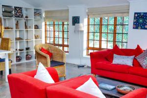 路易特里哈特马迪塔瓦山林小屋的客厅配有红色的沙发和椅子