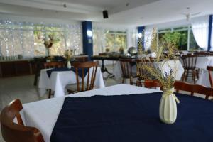 林多亚VILLA DO SOSSEGO pousada的用餐室,配有带花瓶的桌子