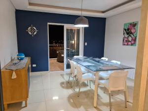 恩卡纳西翁Costanera Encarnación - Apartamento Entero的一间拥有蓝色墙壁和桌椅的用餐室