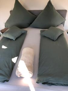 达姆施塔特Wohnen beim Brotsommelier - Alpenkruste的一张带绿色枕头的床和毛巾