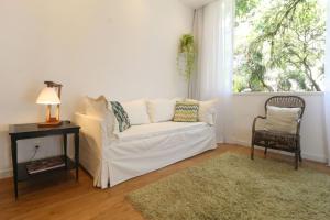 里约热内卢Leblon House IV的客厅配有白色沙发和窗户